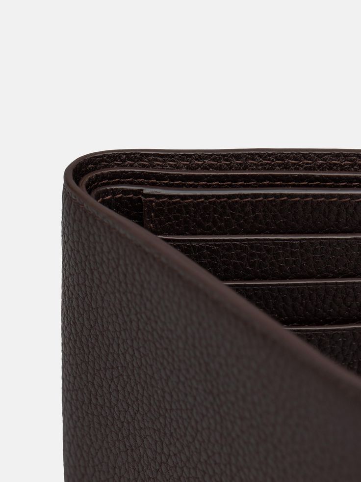 Developed to house all the essentials, The Wallet in brown grain features a sleek, understated folded design with two full-width compartments for notes and six card slots. The supple, grained leather adds a smooth touch that guarantees it will age gracefully, developing a beautiful patina as it joins you in your everyday life.   The Wallet is handmade in Ubrique, Spain. Luxury Brown Trifold Wallet With Coin Pocket, Classic Brown Trifold Wallet For Formal Occasions, Brown Trifold Wallet With Card Slots For Business, Luxury Brown Trifold Wallet With Interior Card Slots, Brown Business Trifold Wallet With Card Slots, Luxury Leather Wallet With Grained Texture, Classic Brown Trifold Wallet For Business, Classic Brown Trifold Wallet With Leather Lining, Classic Brown Trifold Wallet With Coin Pocket