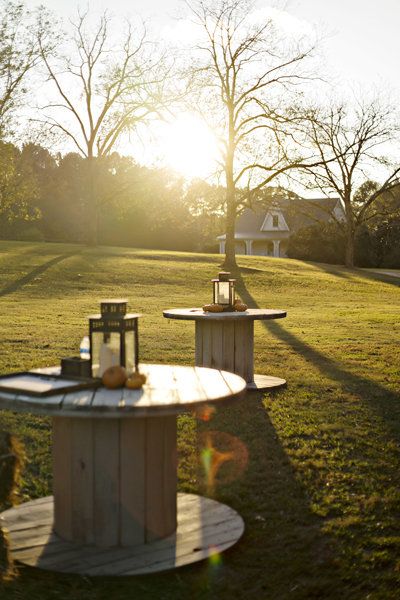 an image of two benches in the grass with sun shining through trees and buildings behind them