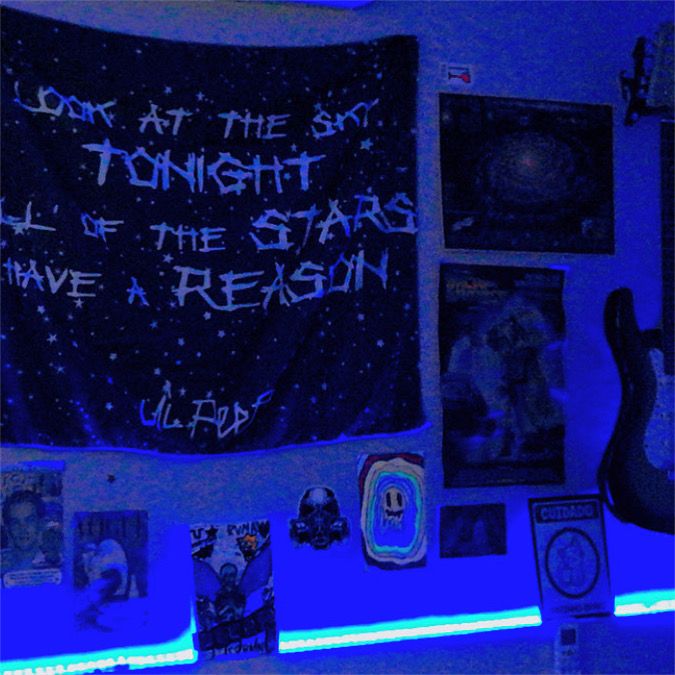 there is a blue light in the room with pictures on the wall and an electric guitar next to it