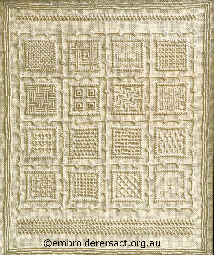 an old fashioned quilt with squares and square designs on it's sides, in cream