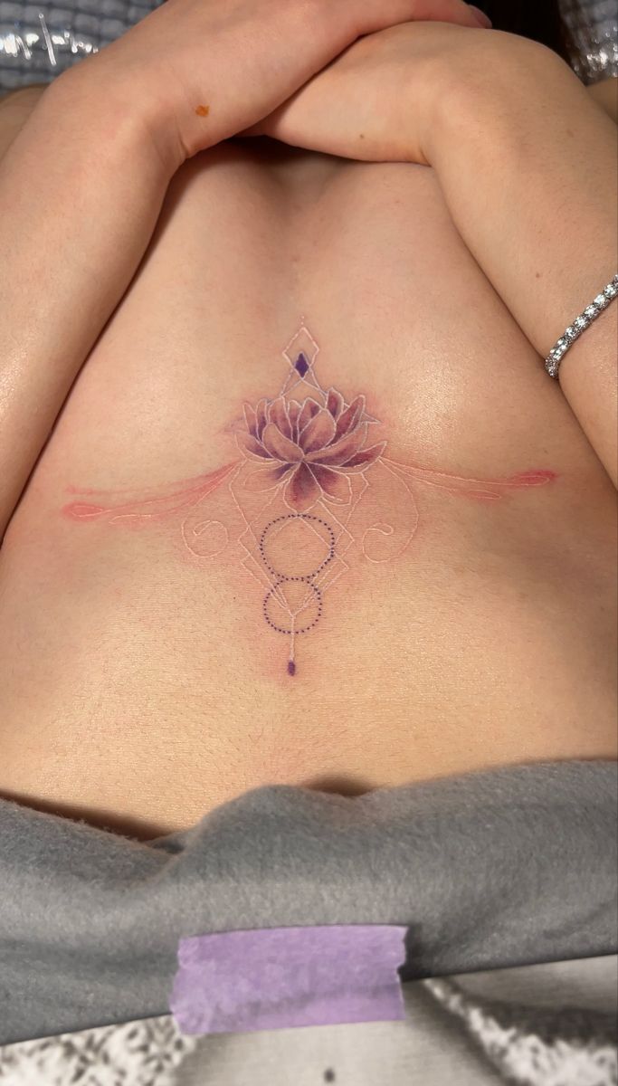 a woman's stomach with a lotus tattoo on it