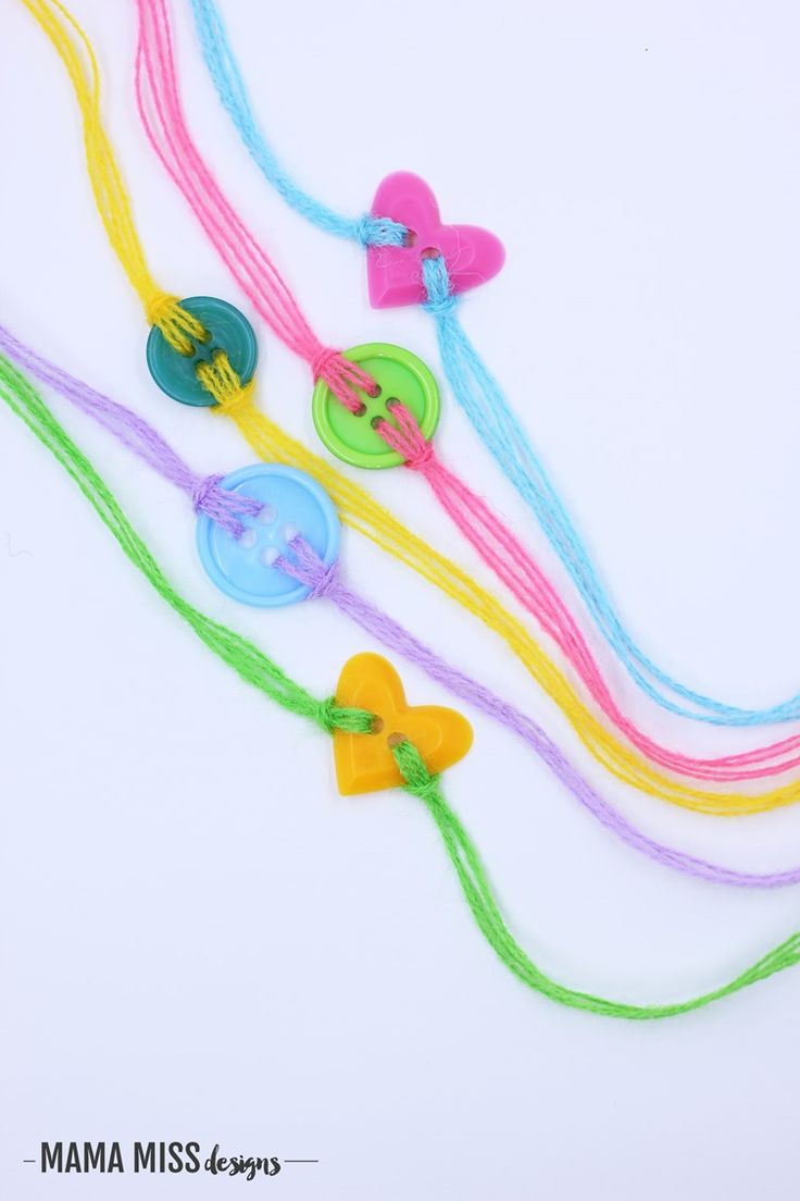 four different colored necklaces with bows and hearts attached to each other on a white background