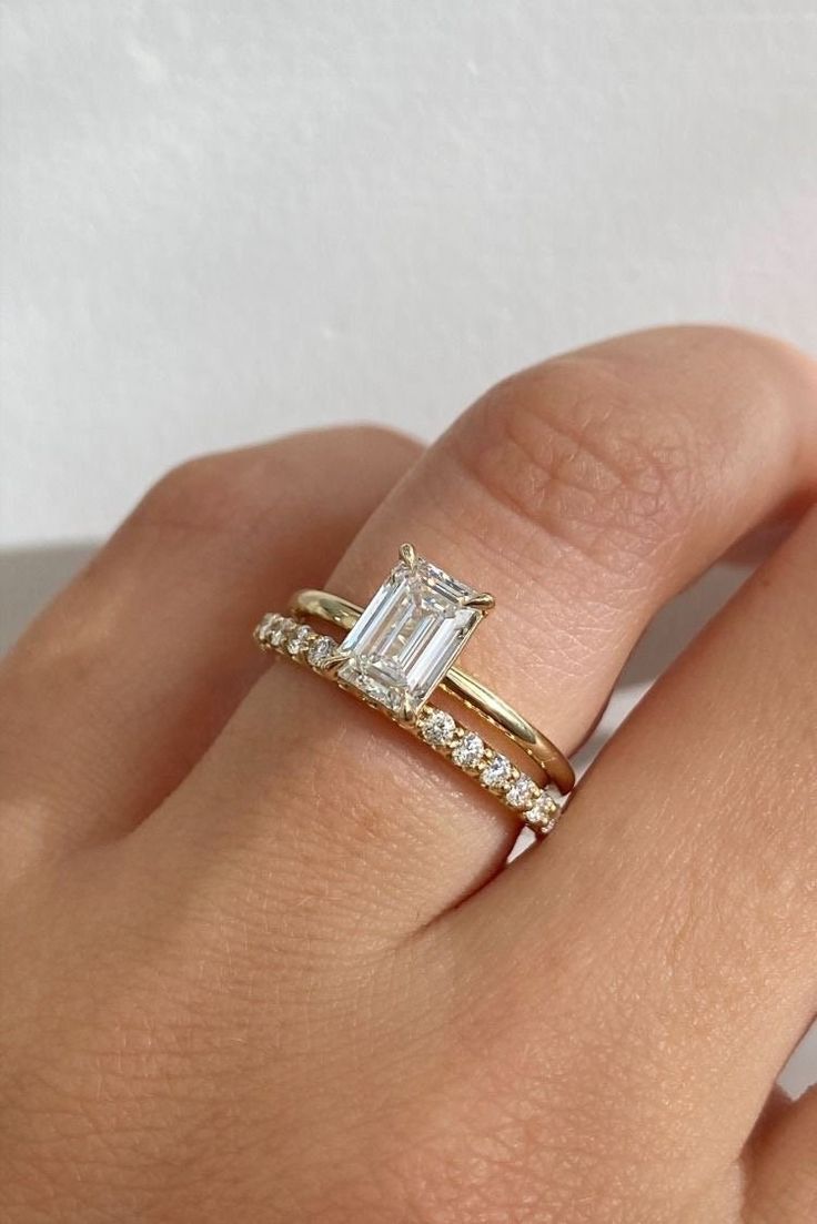 a woman's hand with a gold ring and diamond band on her left wrist