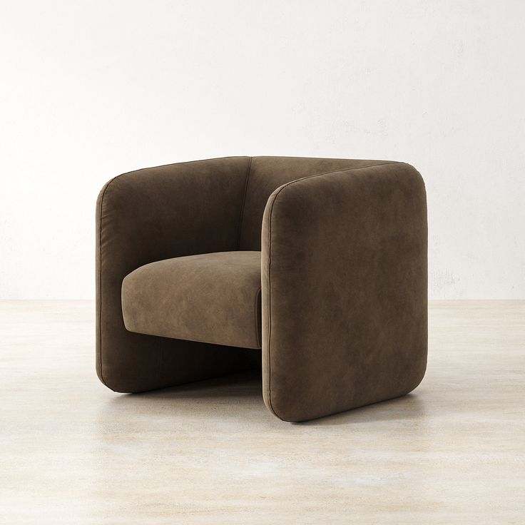 a brown chair sitting on top of a hard wood floor next to a white wall