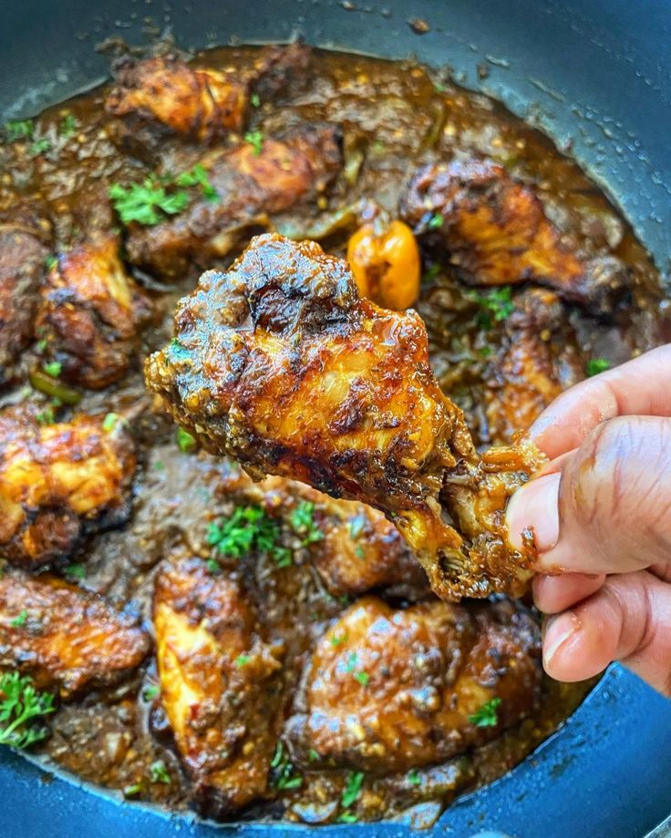 someone is holding a piece of meat in a pan