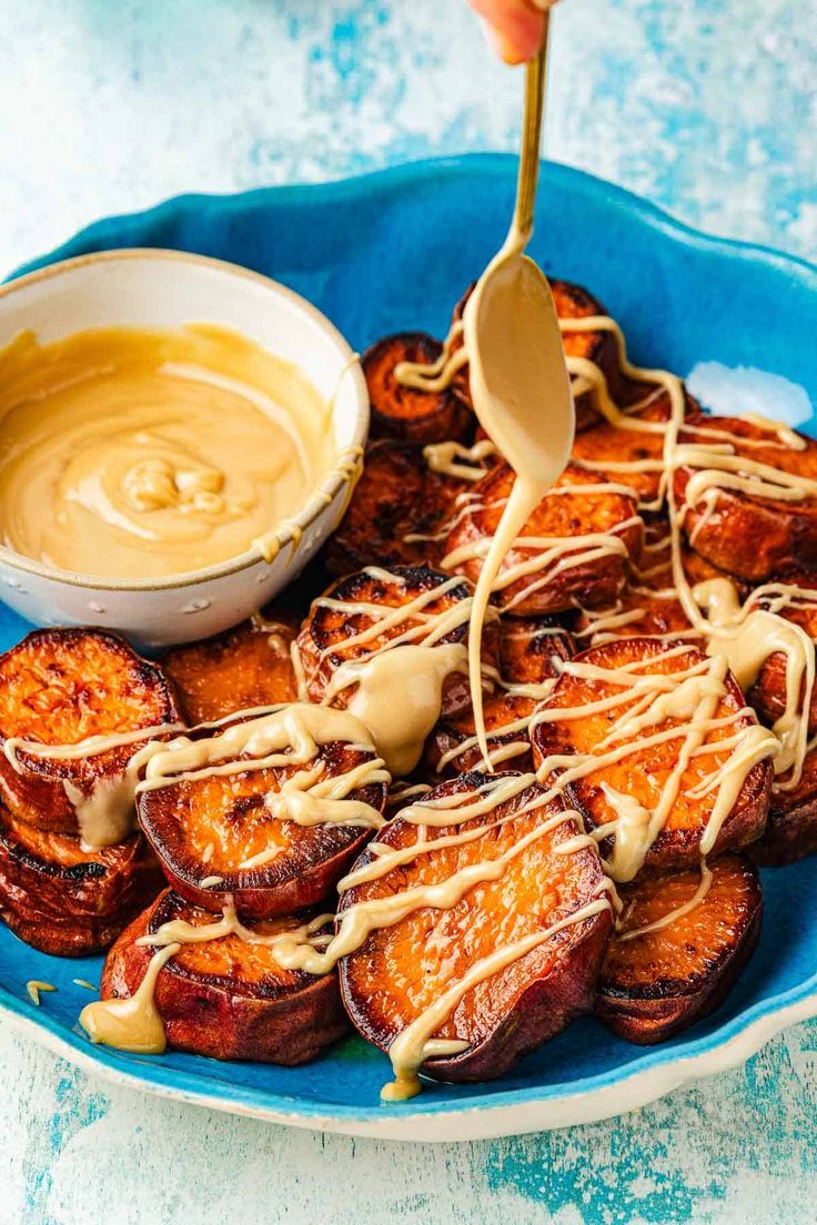 a blue plate topped with grilled bananas covered in caramel sauce and drizzled with icing