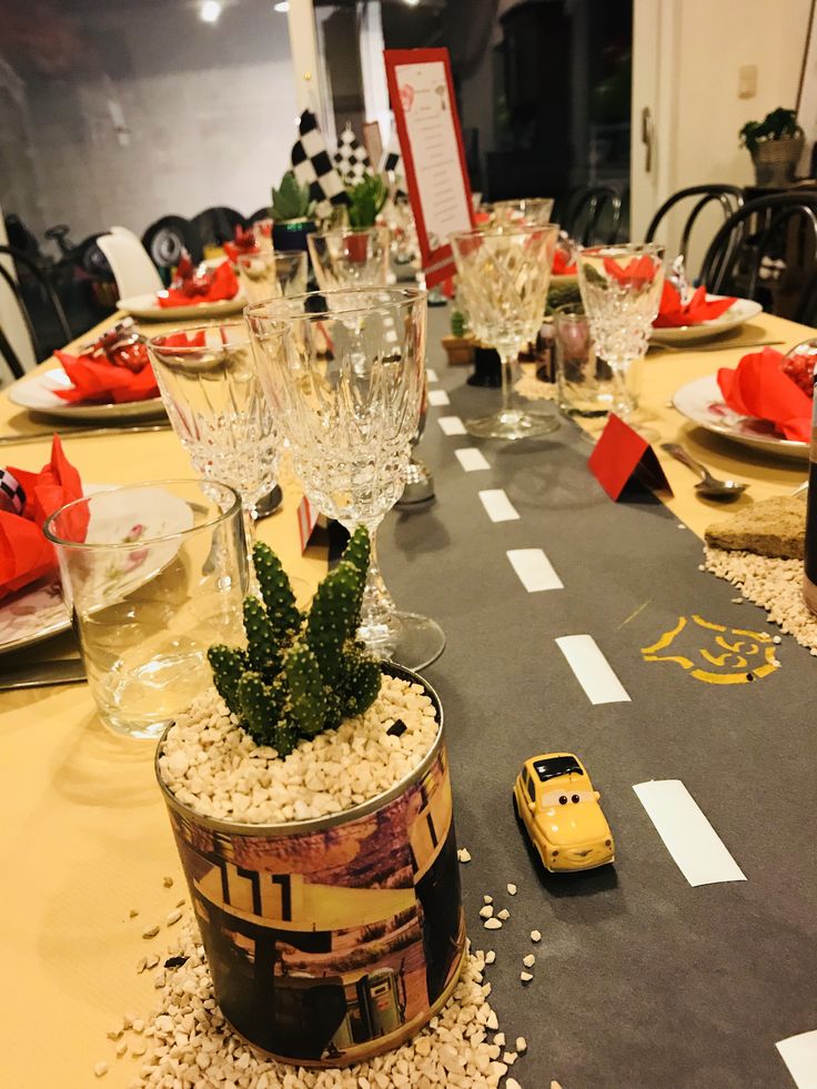 a table set with glasses, plates and cars