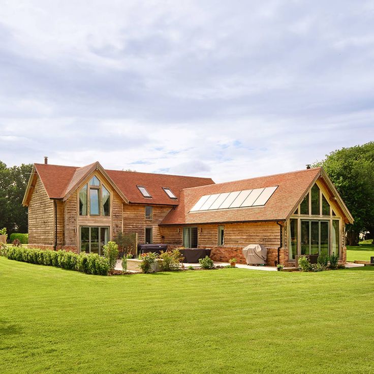 a large house sitting in the middle of a lush green field with lots of trees