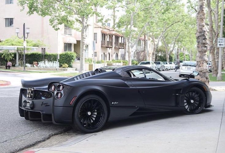 a black sports car is parked on the street