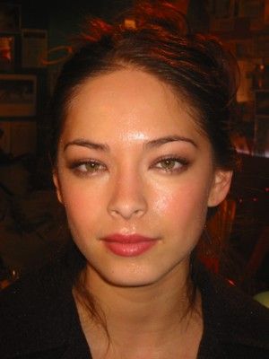 a close up of a person with a cell phone in her hand and a light shining on her face