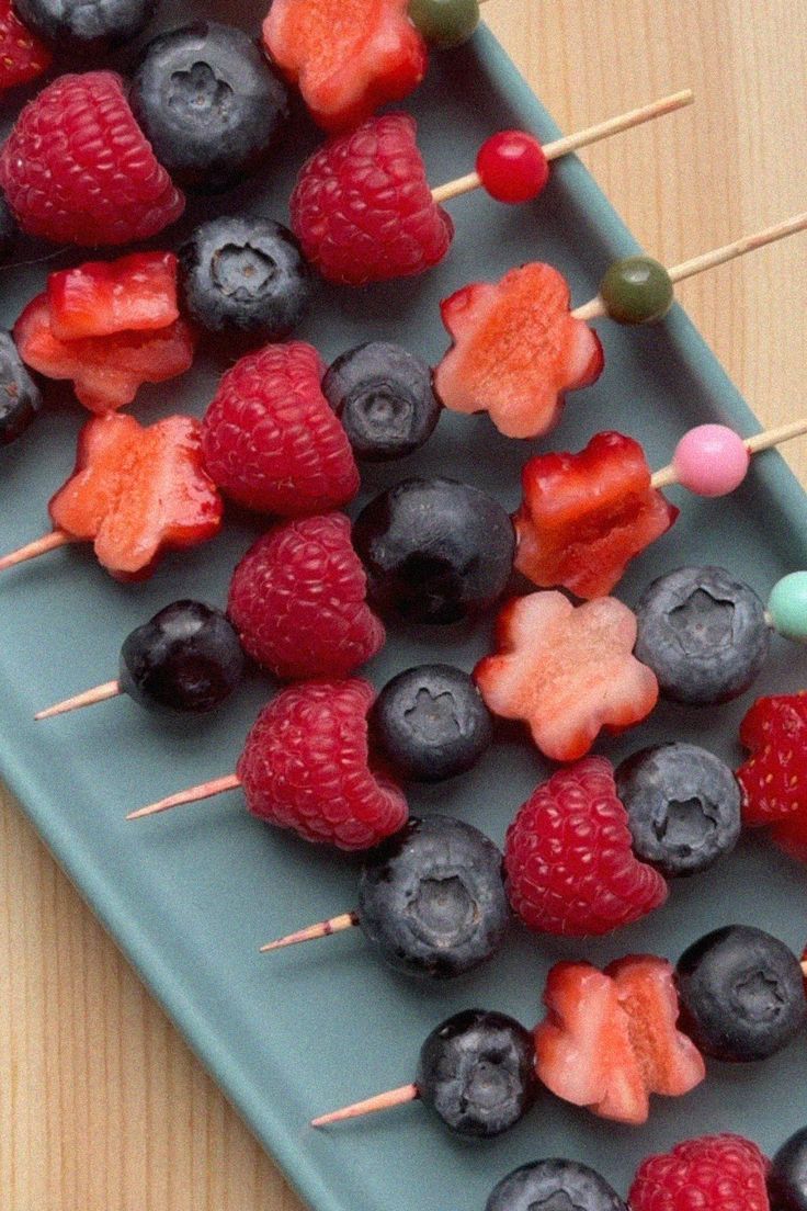 fruit skewers are arranged on a tray