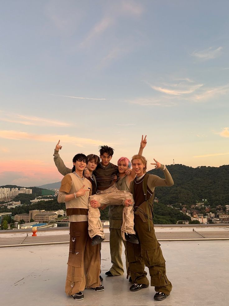 four people posing for the camera with their arms in the air