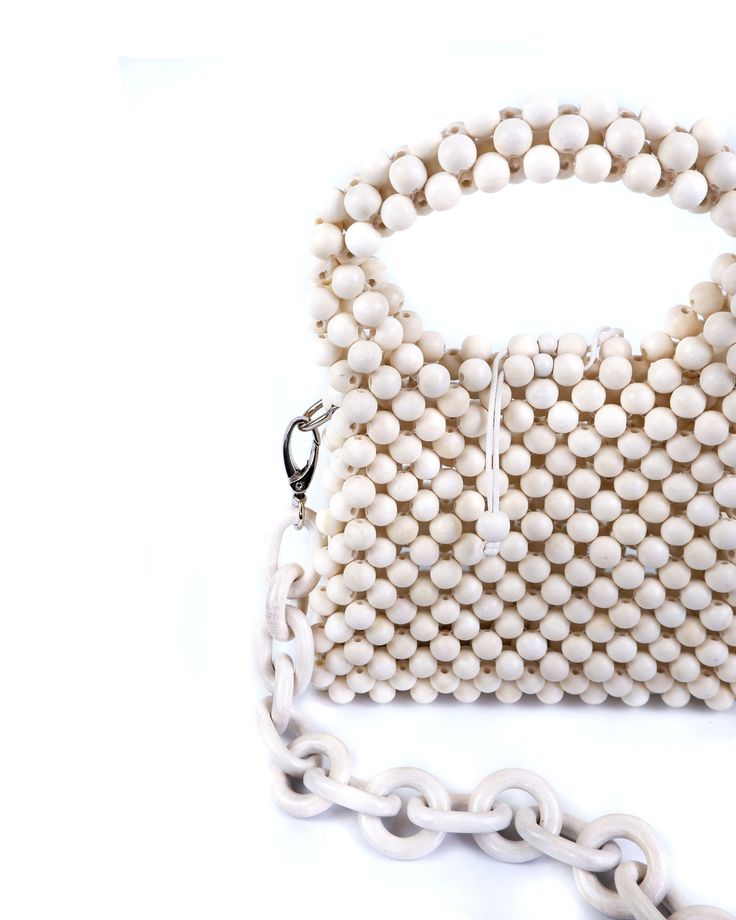 Meet the Poppy handbag, quite a versatile little one but humbly large in looks. This two-way bag is perfect for a boozy brunch or a night out—the ultimate must-have for every fashionista. Now with reimagined hardware, this piece can easily be transformed into your own. Composition: Handmade Wood beads Wood chain Bead slide closure Stainless steel hardware Dimensions: 19cm x 8cm x 15cm (LxWxH) Chic Box Bag With Detachable Handle For On-the-go, Chic Beige Clutch With Top Carry Handle, Trendy Tote Shoulder Bag With Pearl Handle, Chic Satchel Bag With Pearl Handle, Luxury Bags With Pearl Handle For Daily Use, Chic Satchel Shoulder Bag With Pearl Handle, Everyday Beige Shoulder Bag With Pearl Handle, Daily Pearl Handle Satchel Shoulder Bag, Daily Use Pearl Handle Satchel Shoulder Bag