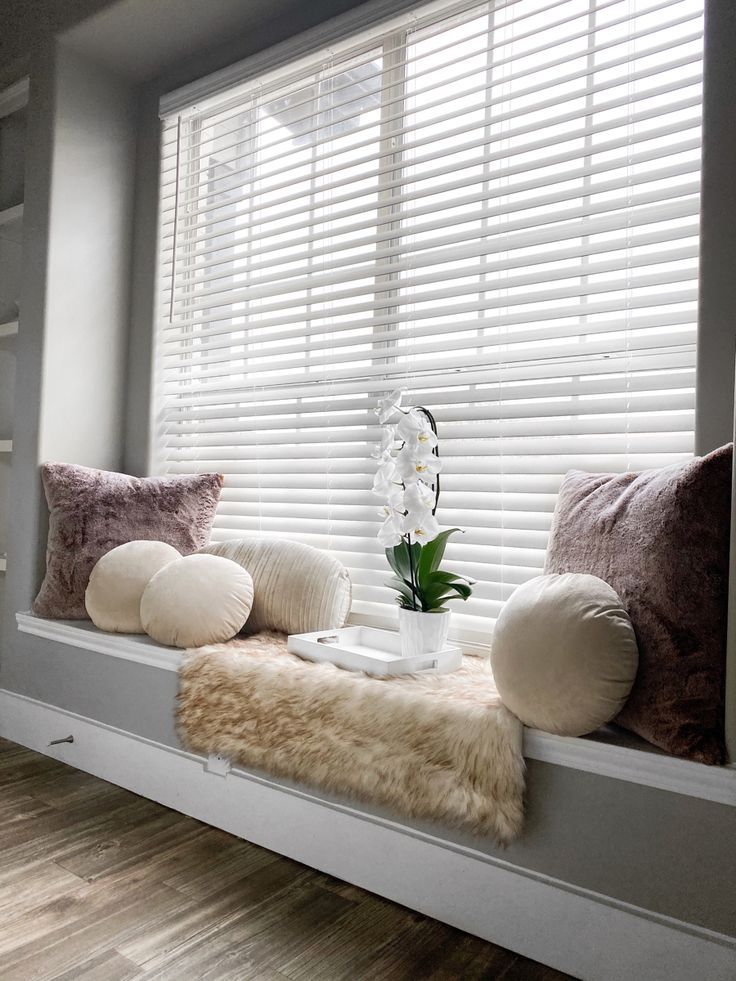 a window sill with pillows and flowers on it