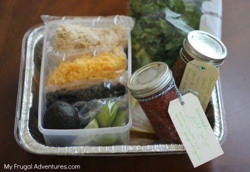 a container filled with lots of food on top of a wooden table