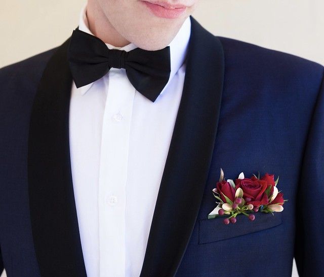 a man in a tuxedo with a boutonniere on his lapel