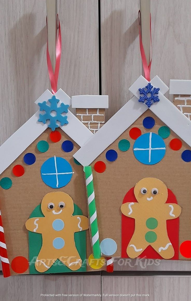 two gingerbread houses made out of cardboard with candy canes and decorations on them