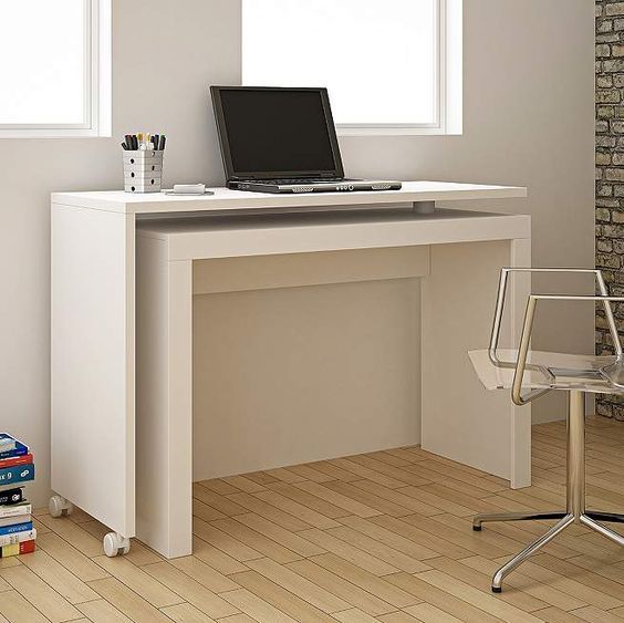 a laptop computer sitting on top of a white desk next to a stack of books