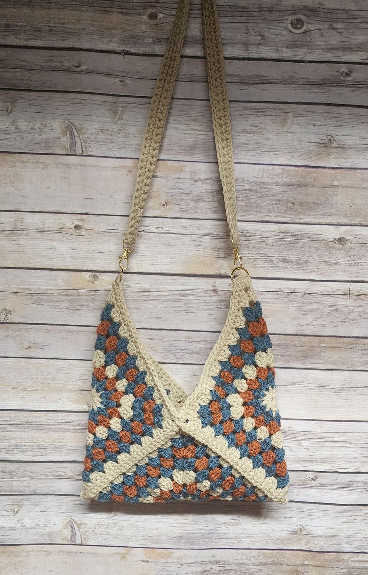 a crocheted purse hanging on a wooden wall