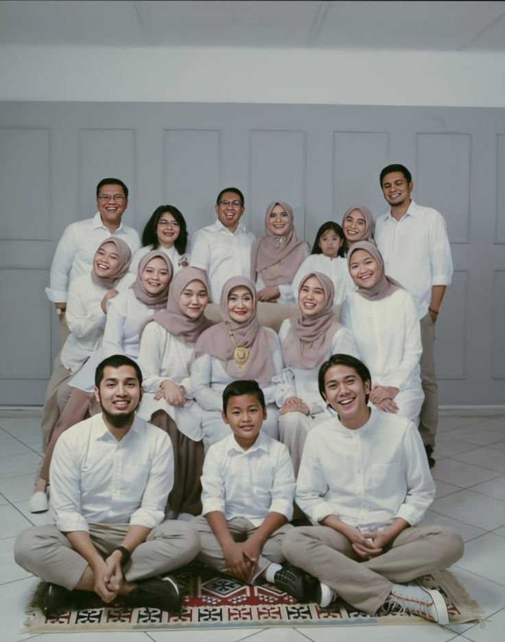 a group of people sitting on top of a rug in front of a white wall