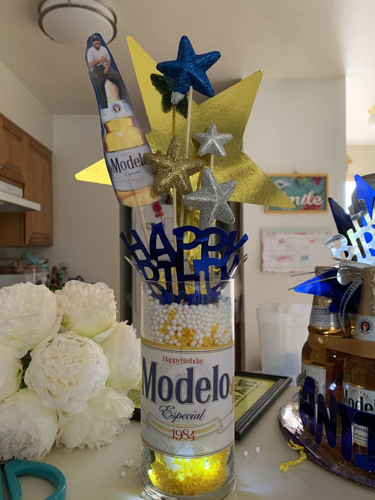 a vase filled with flowers and confetti on top of a counter