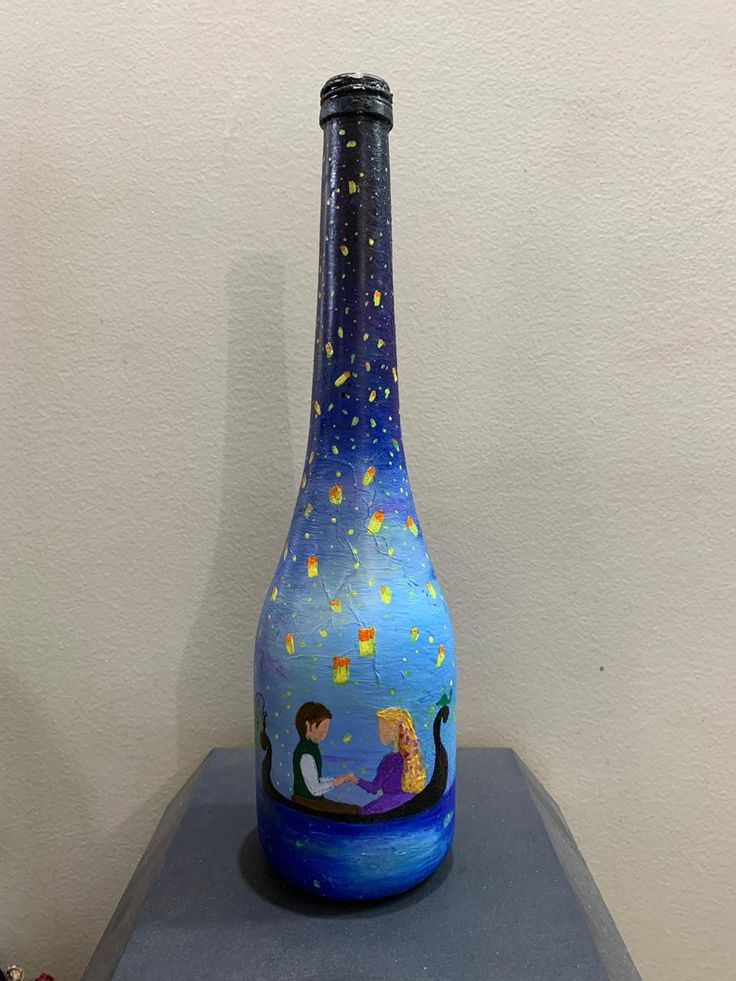 there is a blue glass vase with a little mermaid on it and stars in the sky