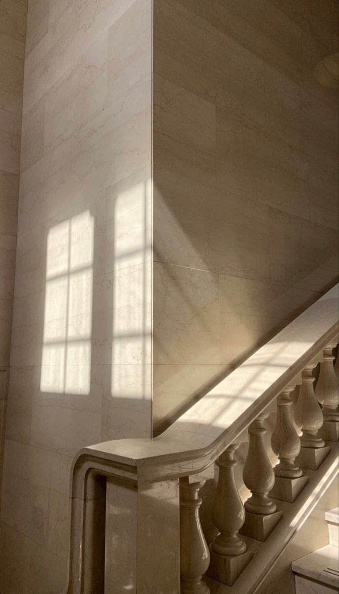 the sun is shining through the windows on the wall next to the stairs in this building