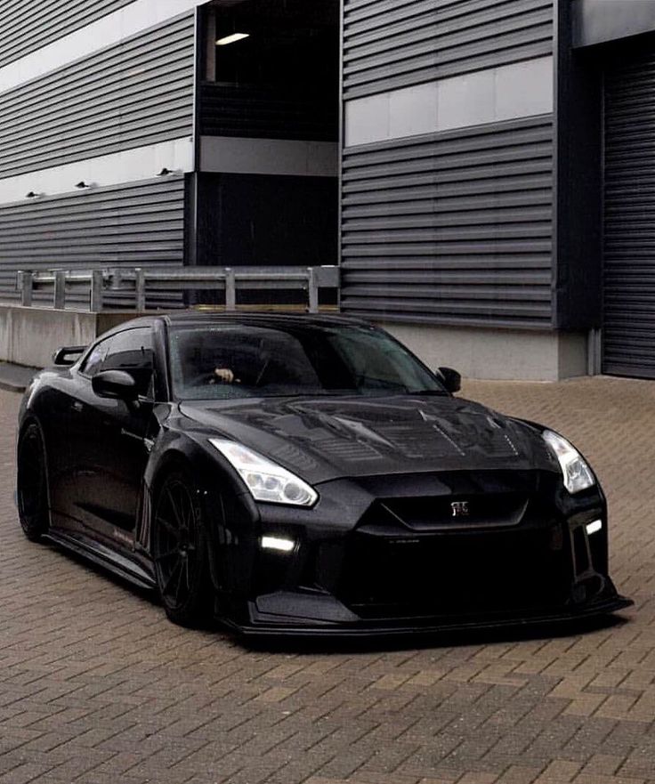 a black sports car parked in front of a building