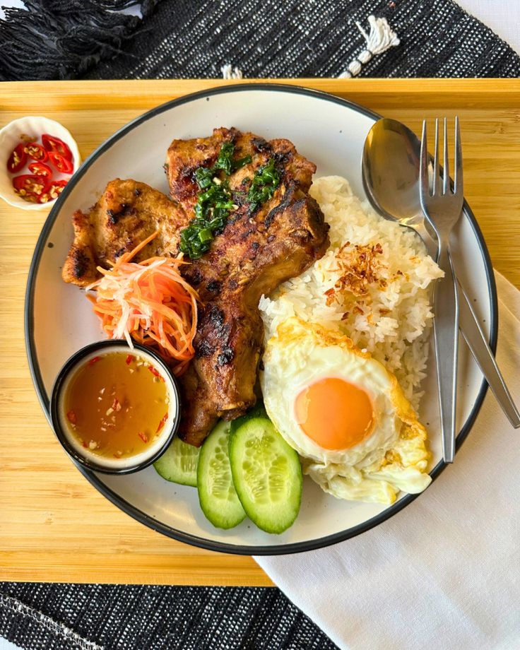 a white plate topped with meat, rice and veggies