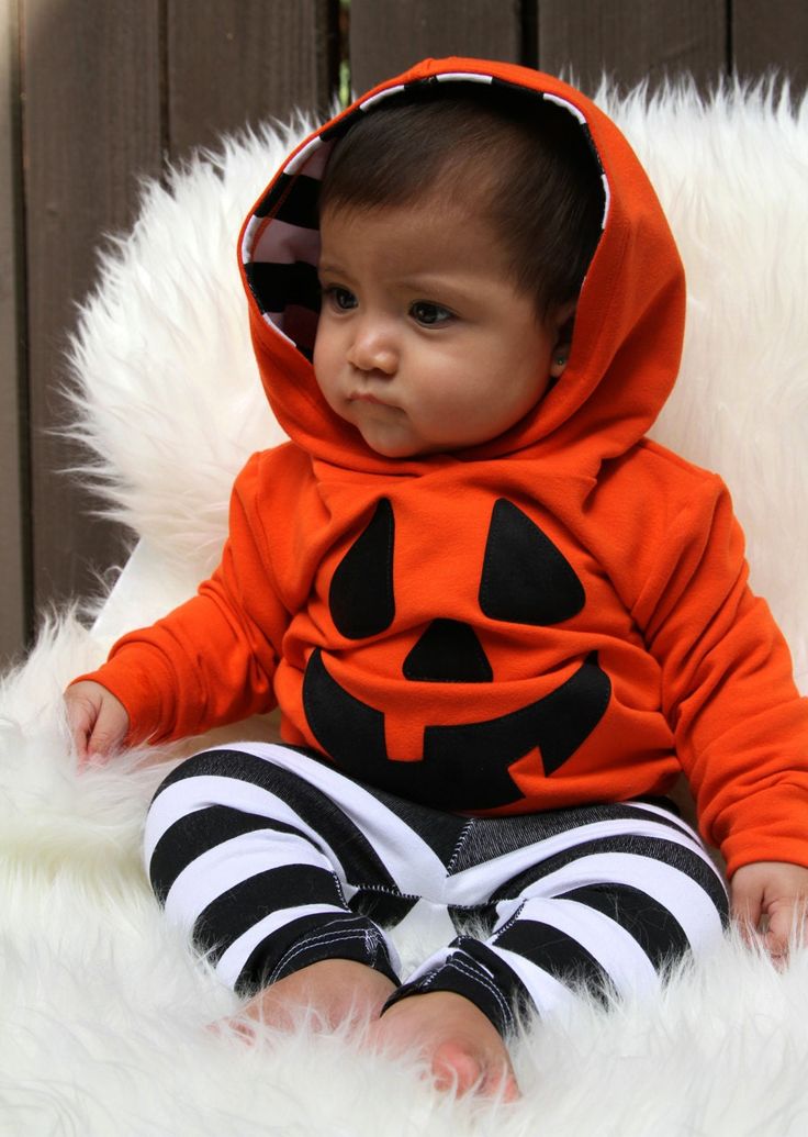 a baby wearing a jack - o'- lantern costume