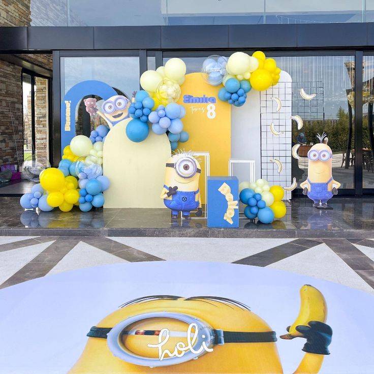 an entrance decorated with balloons and minion characters