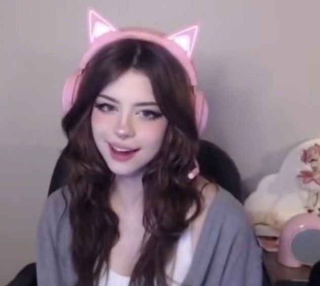 a girl with long brown hair wearing pink headphones and a cat ears on her head