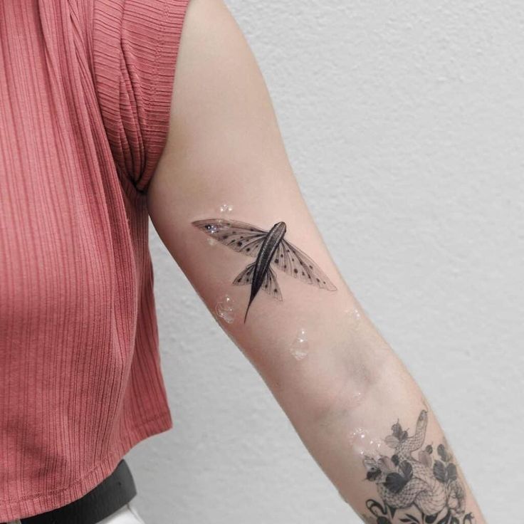 a woman's arm with a small tattoo on the left side of her arm