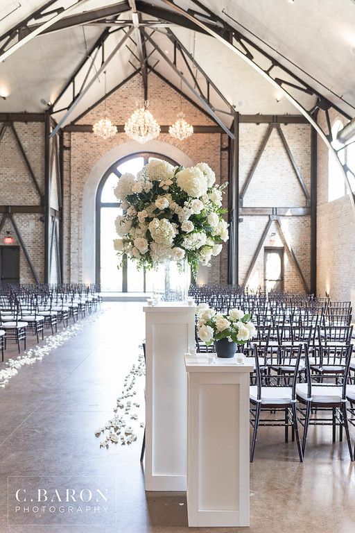 an indoor venue with rows of chairs and white flowers