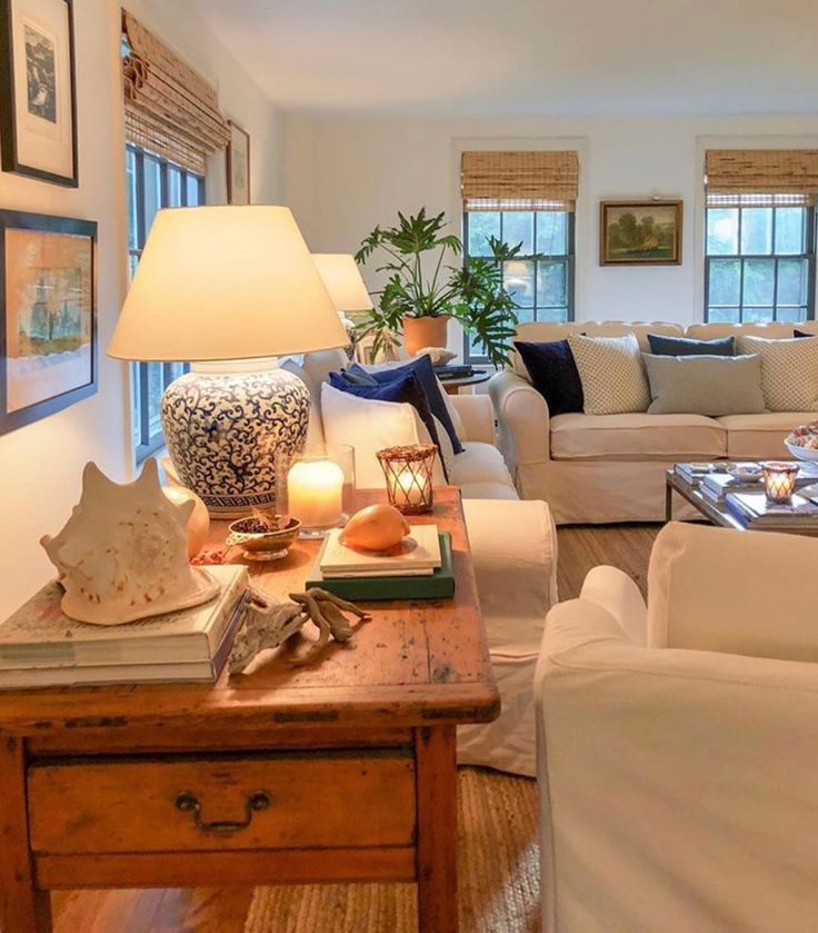 a living room filled with furniture and a lamp on top of a wooden coffee table