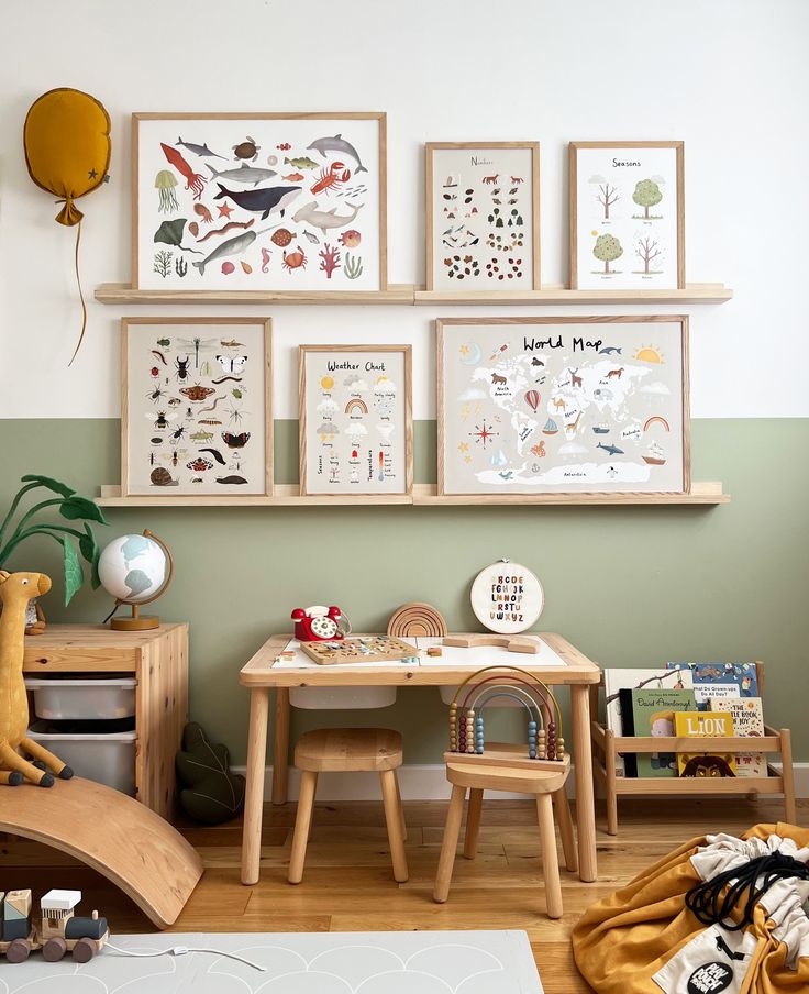 a child's playroom with toys and artwork on the wall, including two children's table and chairs