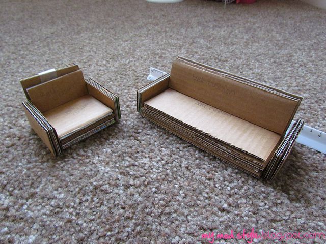 two cardboard couches sitting on top of a carpeted floor next to each other