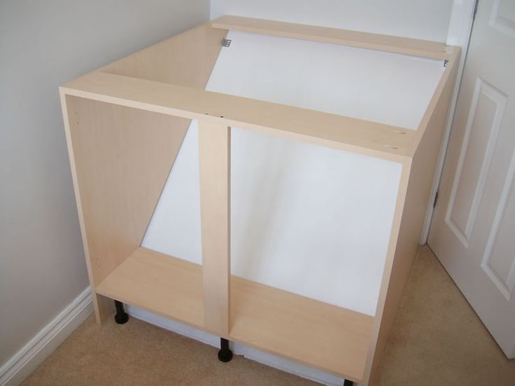 a white cabinet sitting in the corner of a room next to a door and carpeted floor