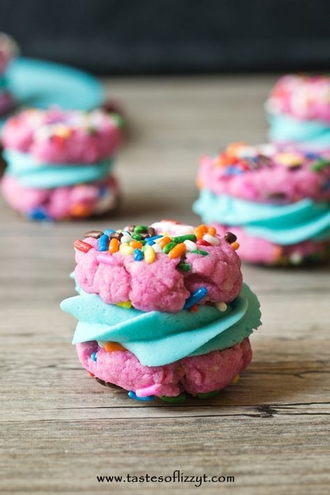 colorful cookies with sprinkles and blue icing on a wooden table top