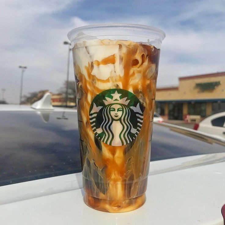 a starbucks cup with ice cream and caramel swirls on the outside of it