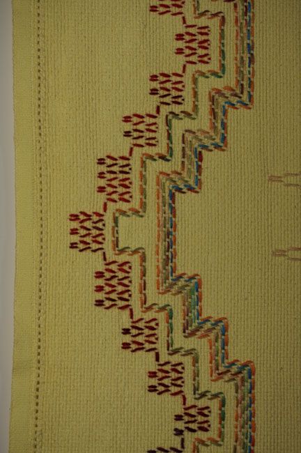 a close up of a blanket with different colors and designs on the bottom, along with an arrow pattern