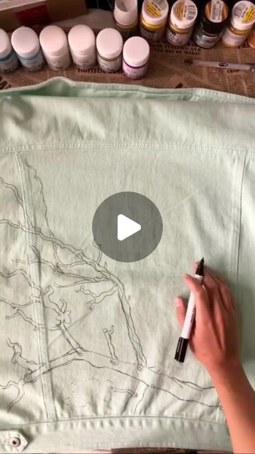 someone is drawing on a piece of fabric