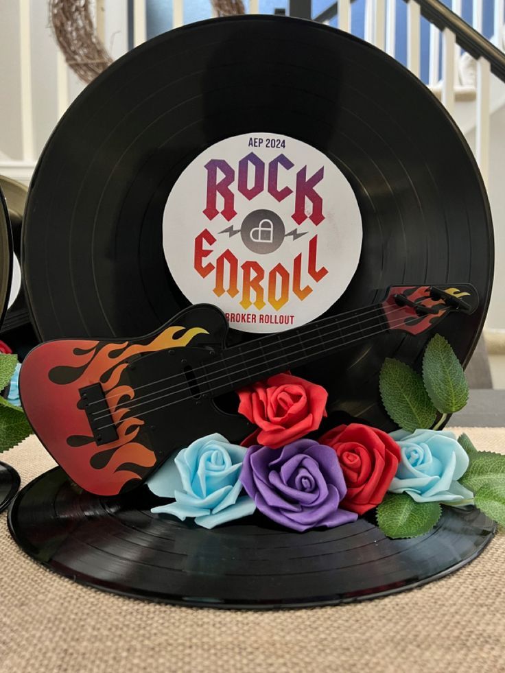 an old record with roses on it and a guitar in the middle next to it