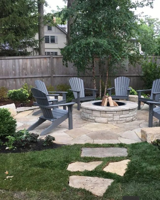 an outdoor fire pit surrounded by chairs