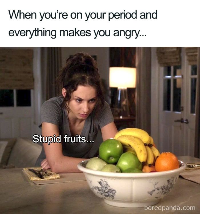 a woman sitting in front of a bowl of fruit