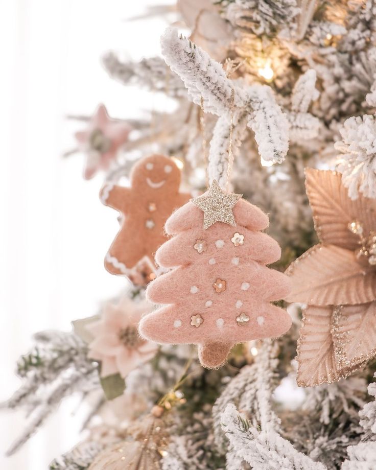 christmas tree decorated with pink and gold ornaments, including two gingerbreads hanging from the top