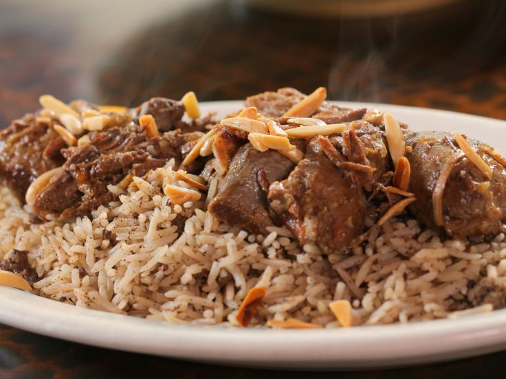 a white plate topped with rice and meat