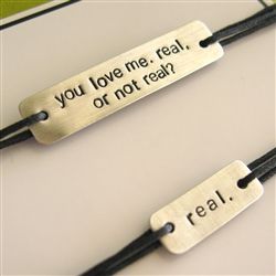 two bracelets that say you love me, real or not real on black cord