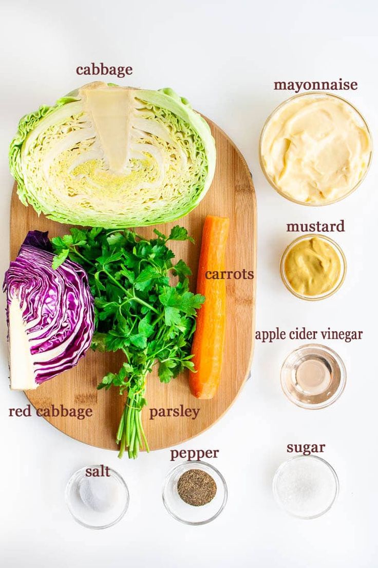 the ingredients to make an artichoke salad laid out on a wooden cutting board