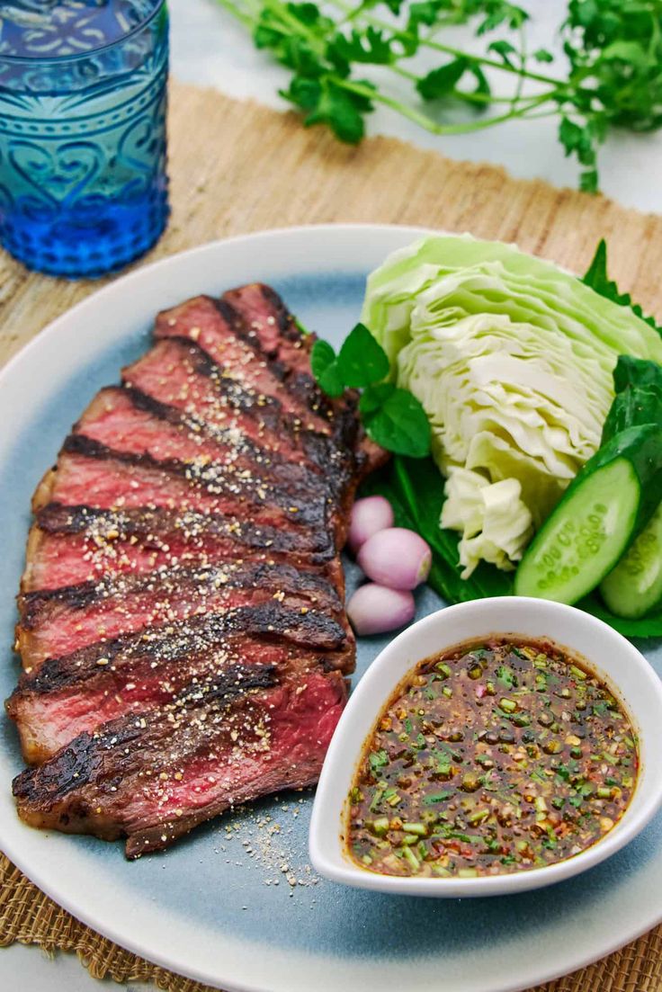 a plate with steak, lettuce and sauce on it